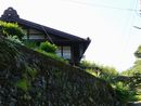 赤沢宿の石段に生える雑草越に見えるノスタルジーな旅館と土蔵の町並み