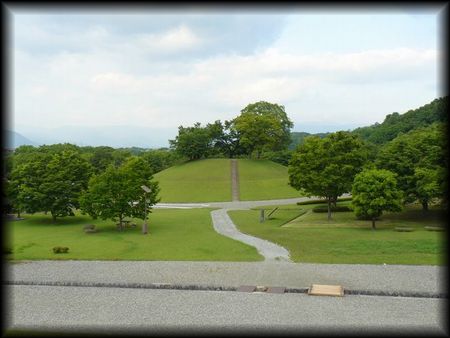 丸山塚古墳の全景画像、木々の緑と芝生の黄緑のコントラストが美しい