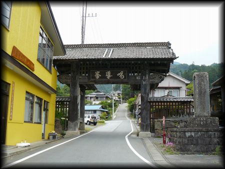 妙法寺門前町の手前に設けられた高麗門形式の総門と石造寺号標