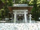 武田八幡宮の歴史ある石造鳥居と苔むした石垣を写した写真
